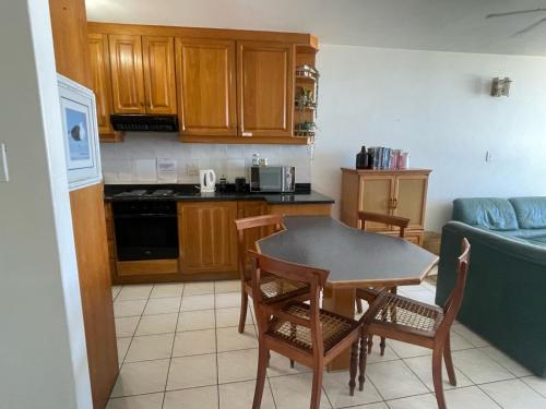 a kitchen with a table and chairs and a couch at Peacehaven 406 in Scottburgh