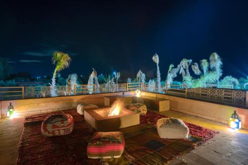 a patio with a fire pit and fountain at night at Palais Noryalis in Tillouna