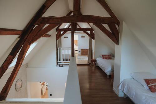 Cette chambre mansardée comprend 2 lits et des poutres apparentes. dans l'établissement La Manova Nature&Détente SPA Sauna Bain Nordique Jacuzzi, à Bourges