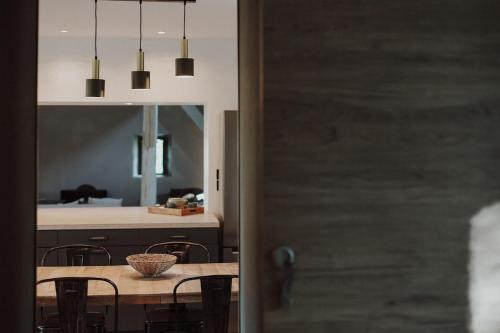 une salle à manger et une cuisine avec une table et des chaises dans l'établissement La Manova Nature&Détente SPA Sauna Bain Nordique Jacuzzi, à Bourges