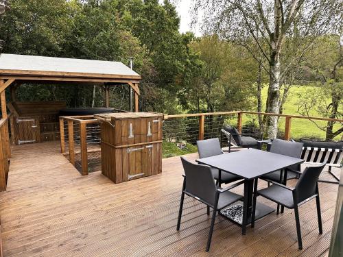 a deck with a table and chairs and a grill at Luna Domes in Chiddingstone