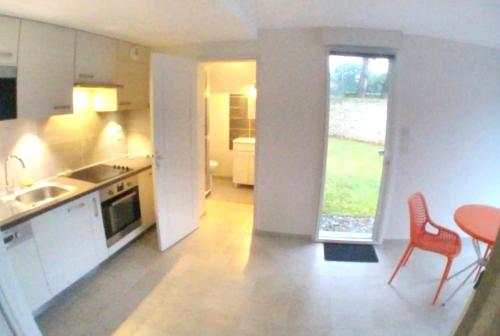 - une cuisine avec une table, 2 chaises et un évier dans l'établissement Studio avec jardin MER à proximité!, à Saint-Malo