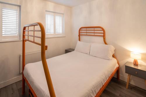 a small bedroom with a bunk bed and two windows at Host & Stay - Coventry Street in Wolverhampton