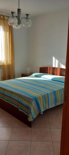 a bedroom with a bed with a striped blanket on it at Sirolo trilocale nuovo con aria condizionata posto auto in Sirolo