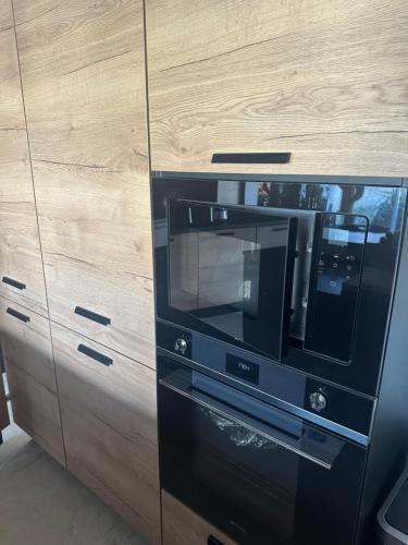 un four micro-ondes noir dans une armoire en bois dans l'établissement Villa Milhaud de luxe, à Milhaud