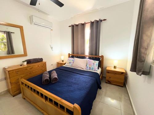 Un dormitorio con una cama azul y dos mesitas de noche. en Cozy Condo - 4 min to the Beach, en Punta Cana