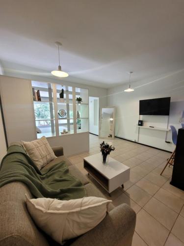 a living room with a couch and a tv at Monoambiente13 Zona Catedral by Lofter in La Plata