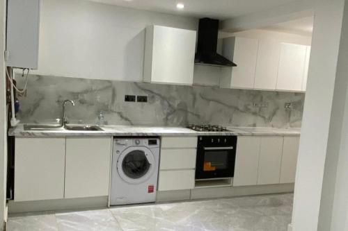 a kitchen with a washing machine and a sink at Coventry Stay - Sleeps 8 Free Parking & Pets in Coventry