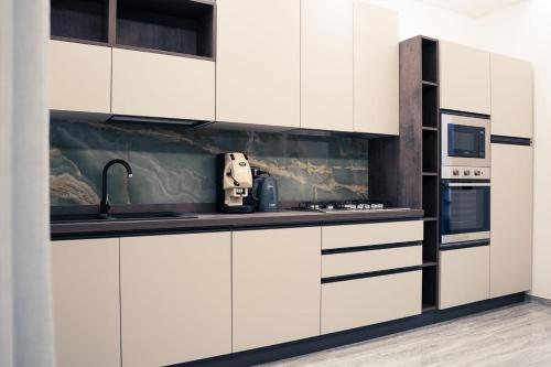 una cucina con mobili bianchi e un lavello di House 21 Residence Room a Collecchio