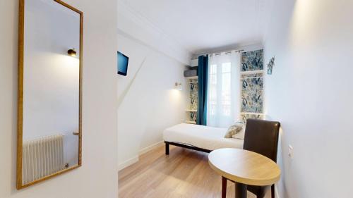 a small room with a table and a mirror at Hotel Solara in Nice