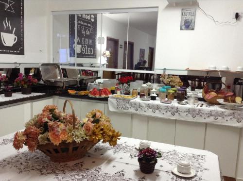 a kitchen with a table with flowers on it at Espaço Alvorada com Banheira ,agendamento das atividades, café da manhã no centro in Brotas