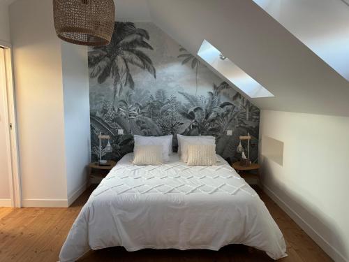 une chambre avec un grand lit avec un tableau au mur dans l'établissement Très bel appartement indépendant de type 2, à Laval