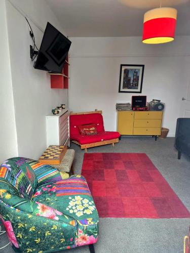 a living room with a couch and a tv at Inalong - Quirky property with sea views above an Ale House in The Mumbles