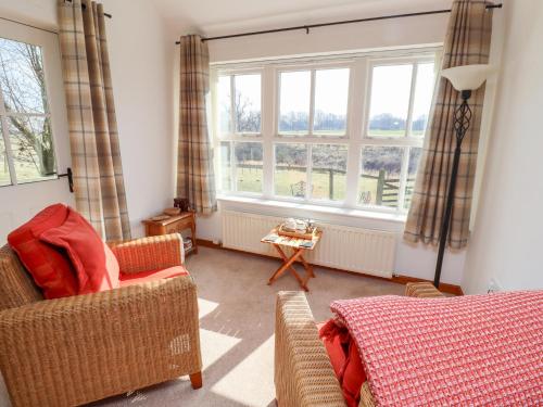 a living room with a couch and two windows at The Bothy in Lowick