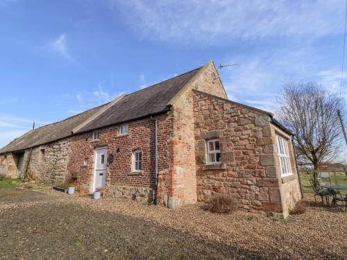 an old brick building with a black roof at The Bothy in Lowick