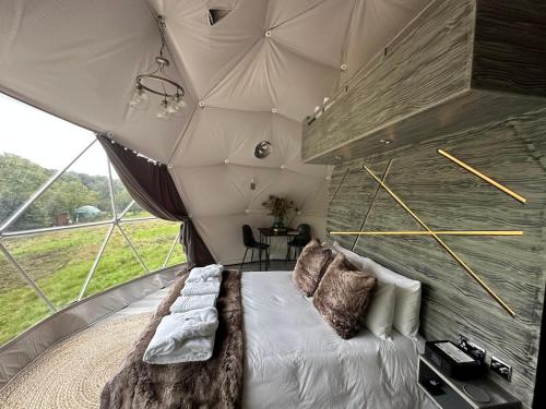a bedroom in a tent with a bed and a table at Luna Domes in Chiddingstone