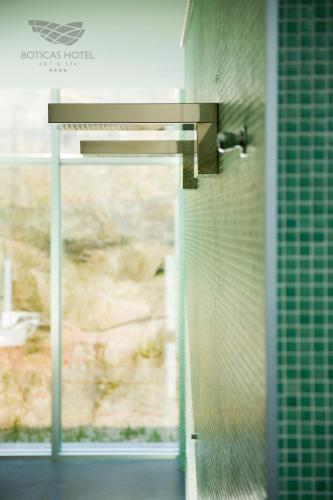 a bathroom with a shower with green tiled walls at Boticas Hotel Art & SPA in Boticas