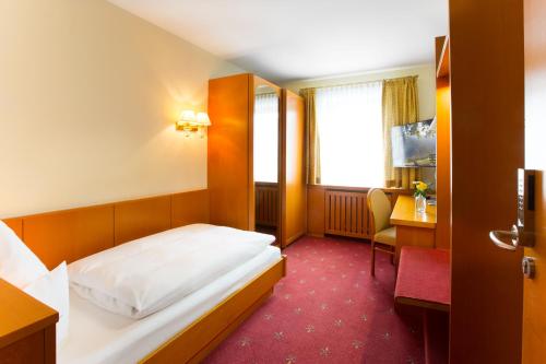 a hotel room with a bed and a desk at AKZENT Hotel Restaurant Altdorfer Hof in Weingarten