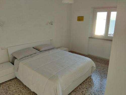 サヴォーナにある4 Finestre sul mareのベッドと窓のある白い寝室