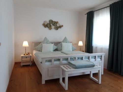 a bedroom with a white bed with blue pillows at Ferienwohnung Pölzl in Chieming