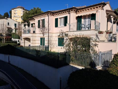 a large white house with a fence in front of it at Sirolo trilocale nuovo con aria condizionata posto auto in Sirolo