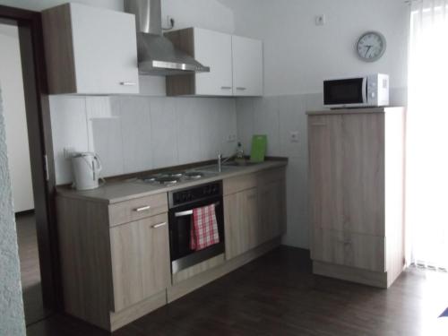 a kitchen with a stove and a microwave at Appartements Vermietung in Industriehof