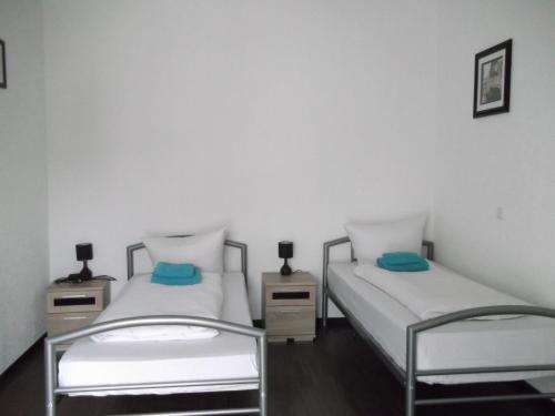 Habitación con 2 camas individuales y paredes blancas. en Appartements Vermietung, en Industriehof