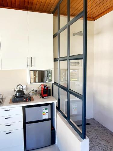 a kitchen with white cabinets and a glass wall at Casa La Mer Guesthouse in Strand