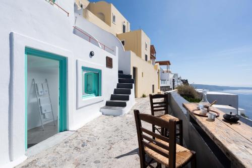 a table and chairs on the side of a building at Sophia Luxury Suites in Imerovigli