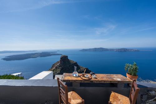 a table with chairs and a view of the ocean at Sophia Luxury Suites in Imerovigli
