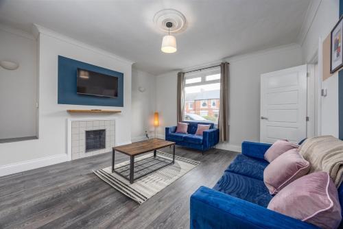 a living room with a blue couch and a table at Cosy 3-BR Home in Seaham not far from the beach in Seaham