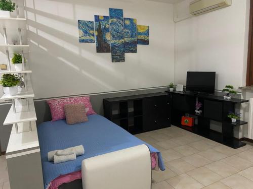 ein Schlafzimmer mit einem Bett und einem Fernseher in der Unterkunft Two-room apartment in Voghera's historic center in Voghera