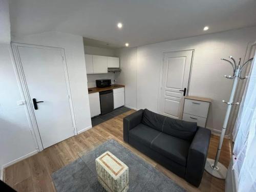 a living room with a couch and a kitchen at Petit havre de paix à Bobigny avec jardin in Bobigny