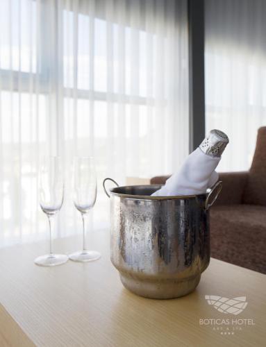 a bucket with a bottle in it next to two wine glasses at Boticas Hotel Art & SPA in Boticas