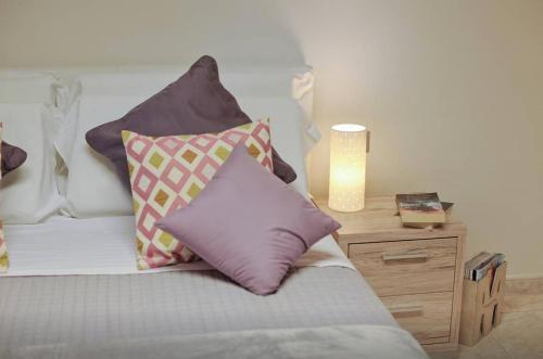a bedroom with a bed with pillows and a table at Residenze Su Planu in Cagliari