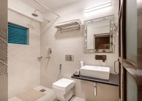 a bathroom with a toilet and a sink and a mirror at Hotel Country Villa in Nagarkot
