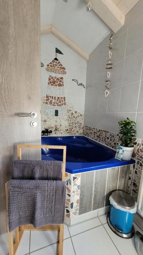 a bathroom with a blue tub in a room at Biggy's Apartment in Selb