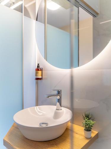 a bathroom with a sink and a mirror at Sunset Hotel in Xiropigado
