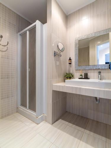 a bathroom with a shower and a sink at Sunset Hotel in Xiropigado