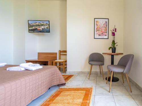 a bedroom with a bed and a table and chairs at Sunset Hotel in Xiropigado