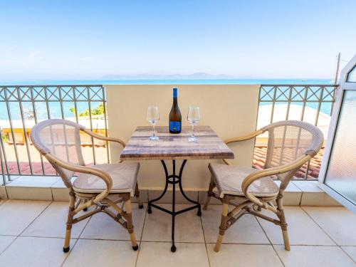 a table with two chairs and a bottle of wine at Sunset Hotel in Xiropigado