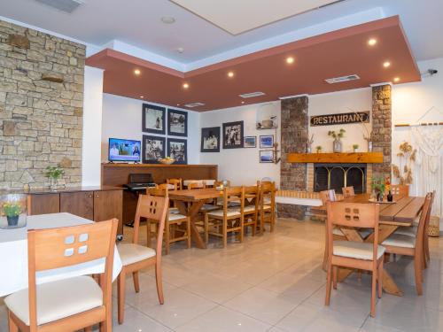 a restaurant with wooden tables and chairs and a fireplace at Sunset Hotel in Xiropigado