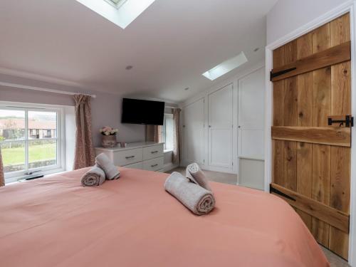 Un dormitorio con una gran cama naranja y una ventana. en The Hayloft, en Richmond