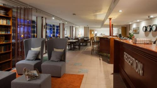 a restaurant with a bar with chairs and a counter at Hotel Kauppi in Tampere