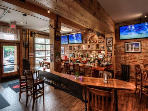 un bar con mesas de madera y sillas en un restaurante en Western Hotel & Executive Suites, en Guelph