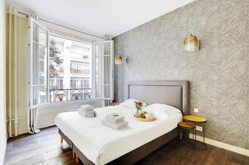 - une chambre avec un lit, des serviettes et une fenêtre dans l'établissement Appartement Beaubourg, à Paris