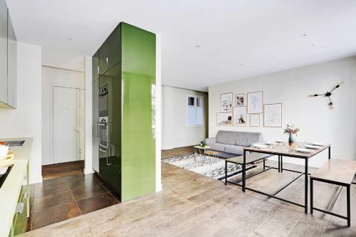 - un salon avec une table et un mur vert dans l'établissement Appartement Beaubourg, à Paris