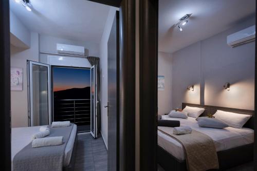 a bedroom with two beds and a large mirror at Akrotiri Panorama- luxury rental apartments with sea view in Rodakino