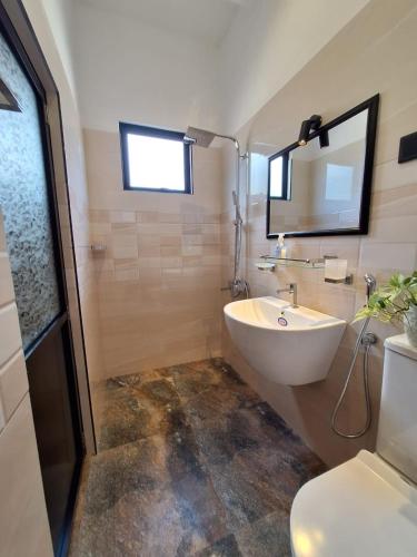 a bathroom with a sink and a shower and a toilet at Adrian Dilneth in Weligama