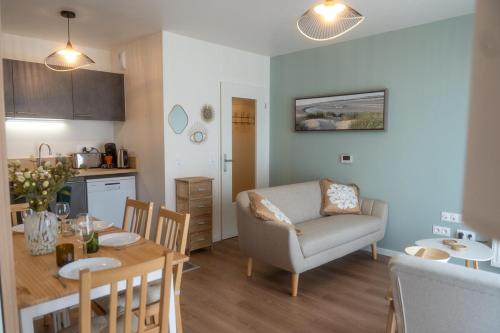 Il comprend une cuisine et un salon avec une table et une chaise. dans l'établissement Chez Edgard et Ernest, balcon et parking, à Saint-Valery-sur-Somme